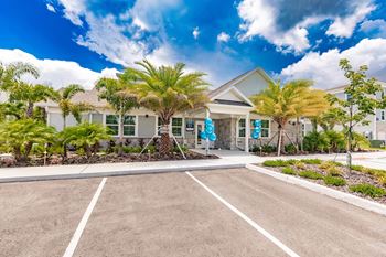 swiftwater luxury apartments clubhouse exterior with palm trees in front in port charlotte fl